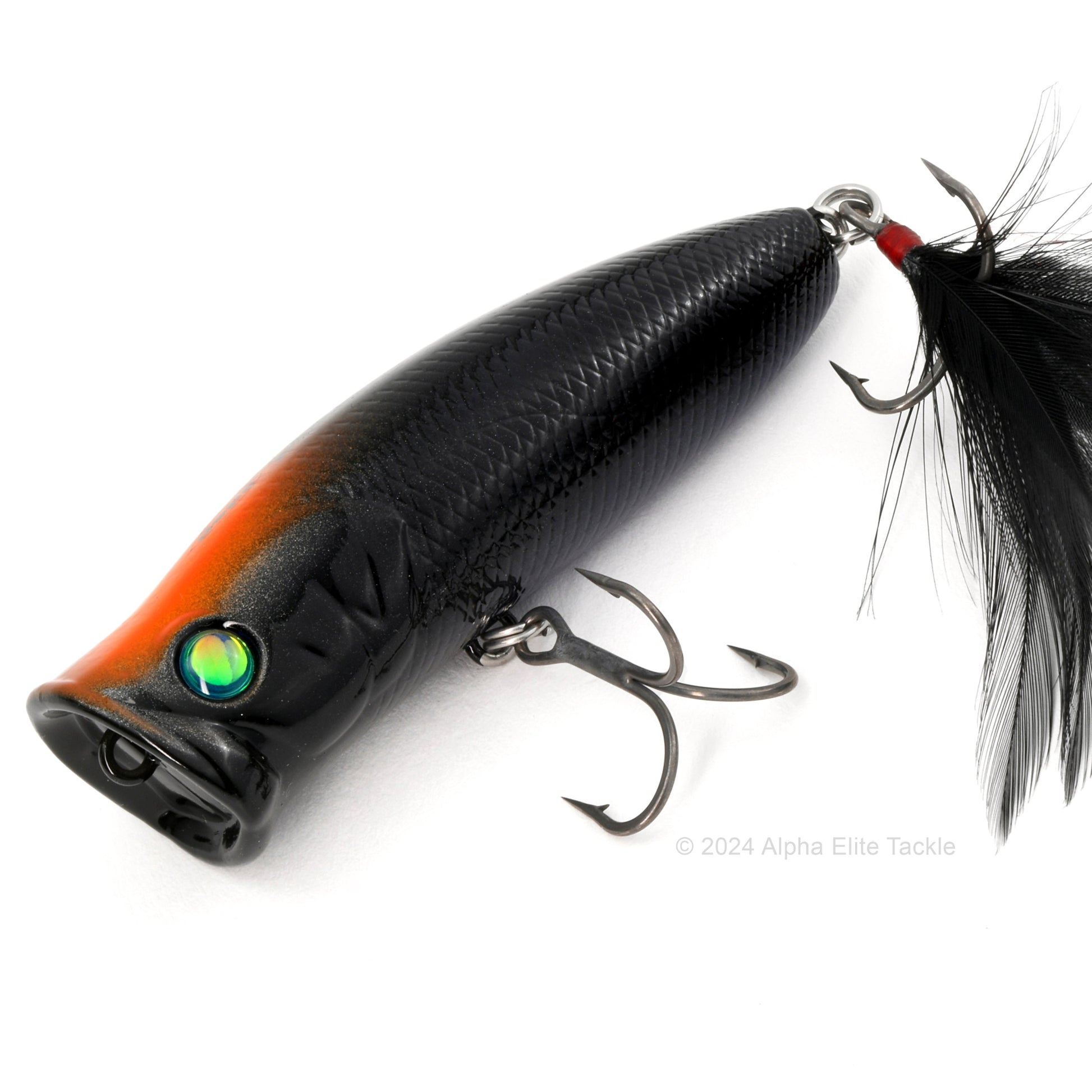 Close up of the Deps Pulsecod Topwater Popper in the color Black Orange Dot on a white background