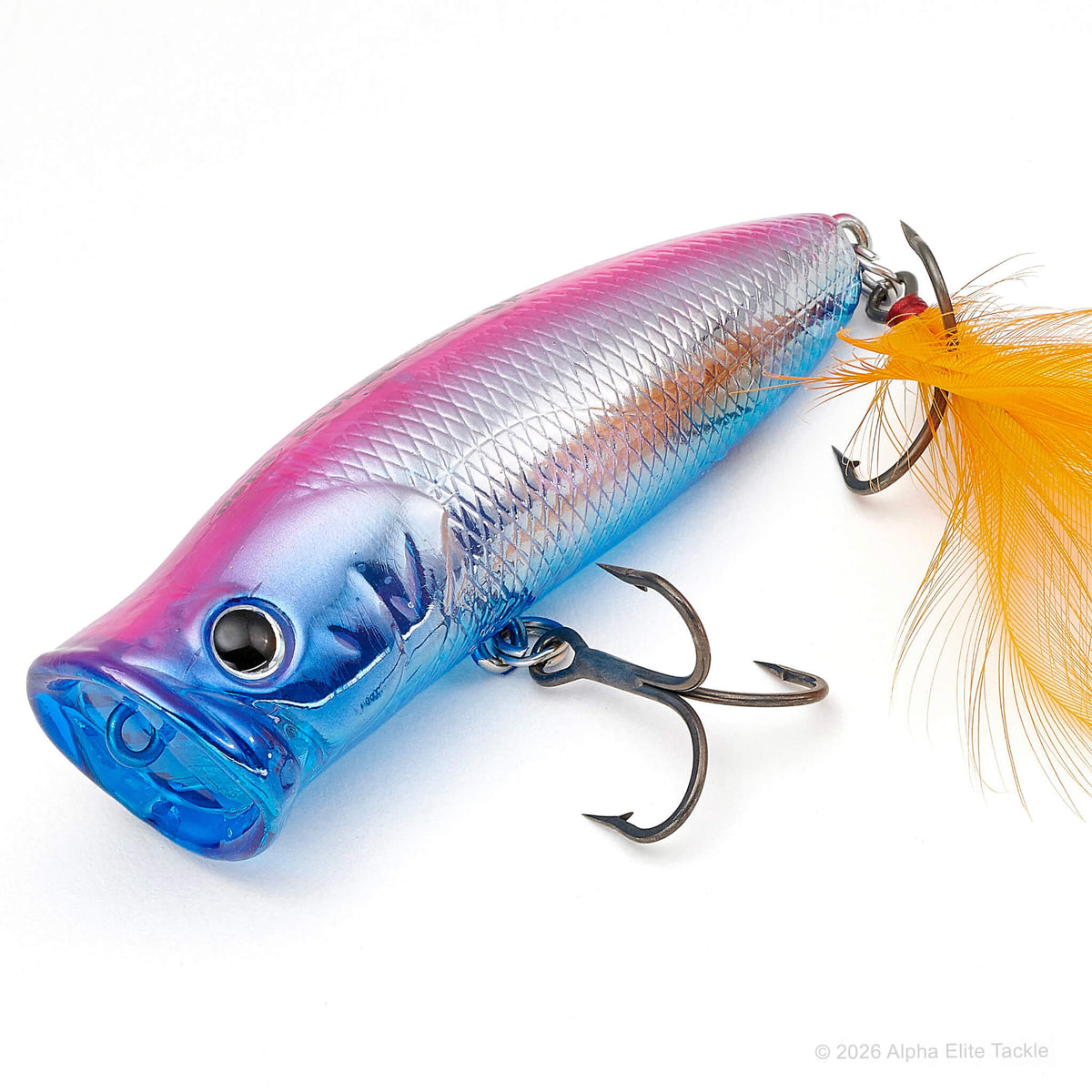 A hard fishing lure with a metallic blue, purple, and pink gradient body, featuring a bright orange feather tail and dark metal treble hooks, shown on a white background.