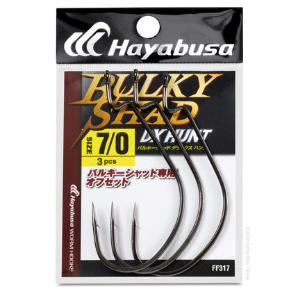 Hayabusa Bulky Shad DX Hunt size 7/0+ fishing hook set in retail packaging, featuring three dark metal hooks on a printed card with black, gold, and white branding.