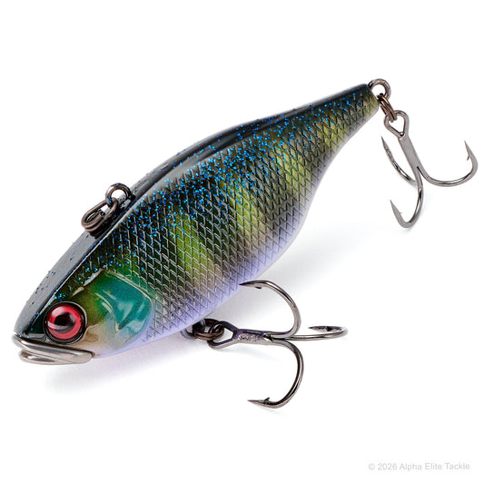 A hard fishing lure with a realistic fish design, featuring a metallic green and blue scale pattern, a red eye, and two treble hooks attached, shown on a white background.