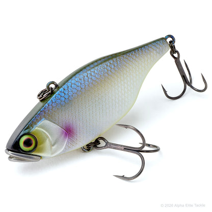 A hard bait fishing lure with a realistic fish design, featuring a silver and blue-green back, a cream belly, a purple accent near the gill, and a detailed eye. It is equipped with two treble hooks and photographed on a clean white background.