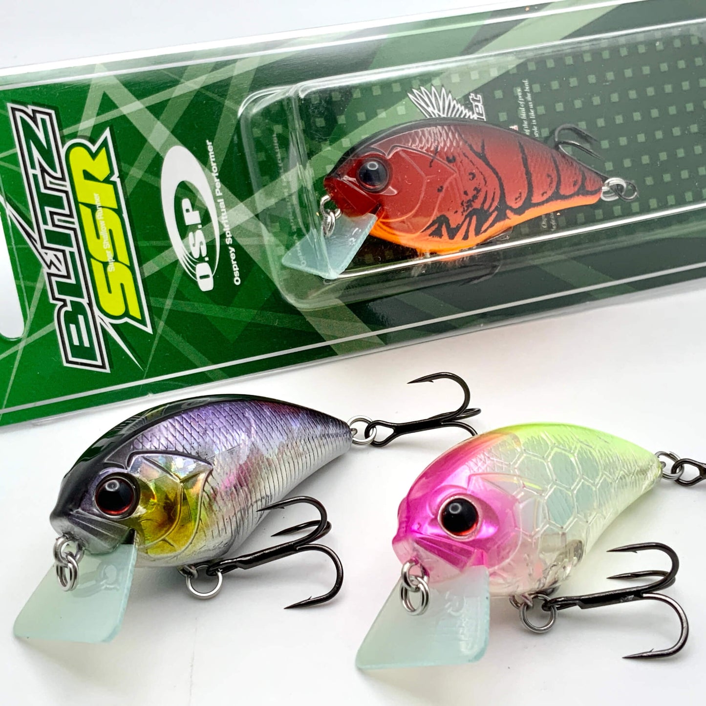 Three colorful fishing lures in front of their packaging on a white background