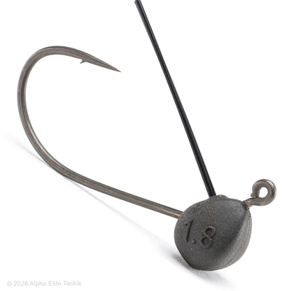 A close-up studio shot of a fishing jig head on a white background, featuring a dark gray textured metal weight with the number '1.8' embossed, a black wire shaft, and a curved silver hook.