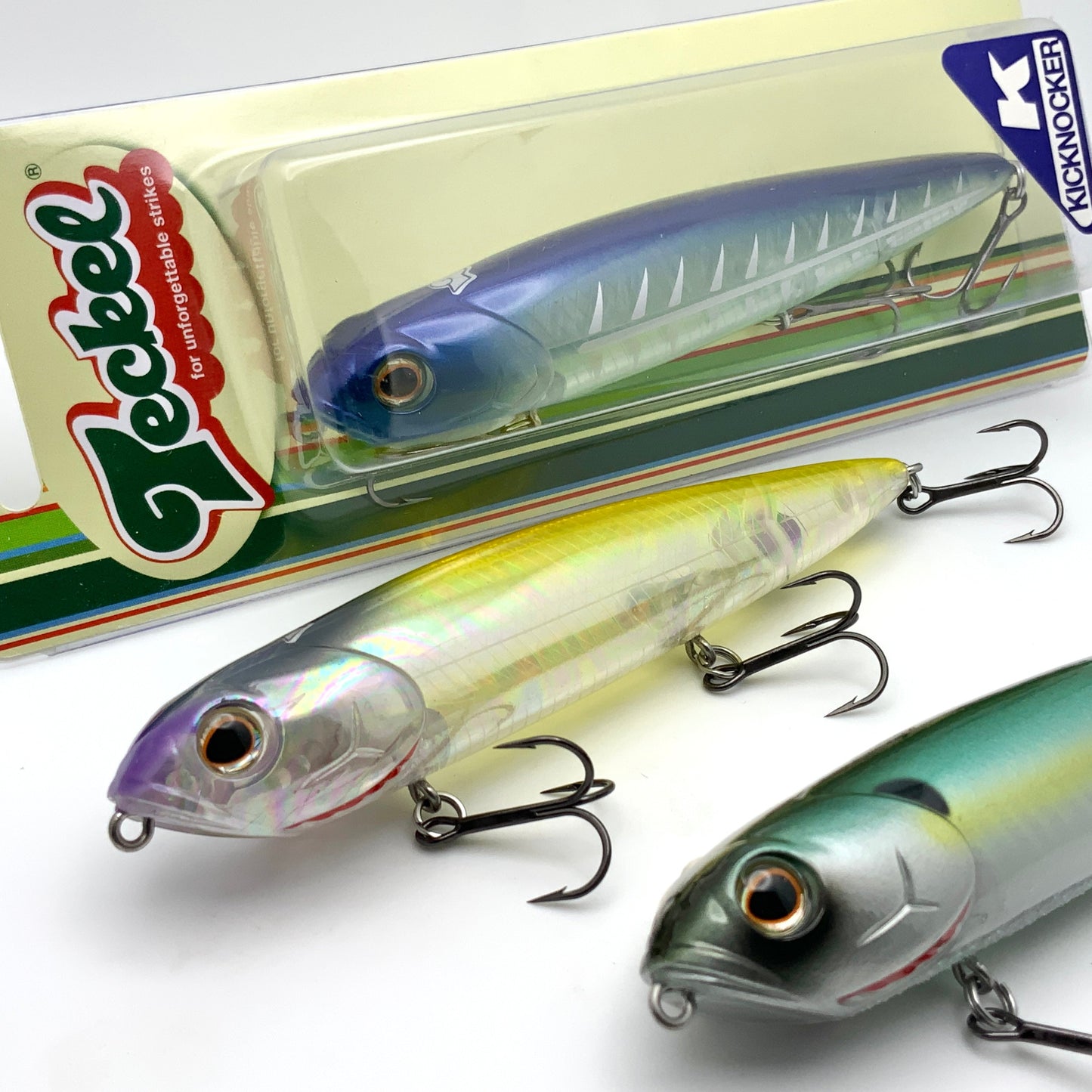 Three fishing lures with packaging featuring Teckel Kicknocker brands on a white background.